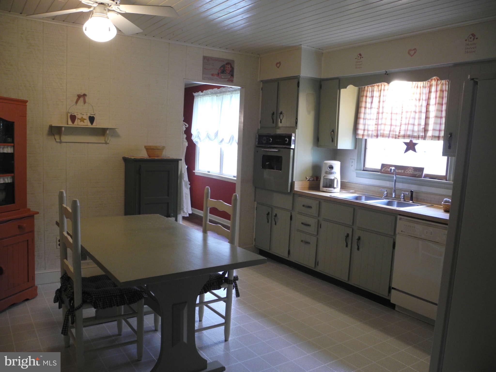 1223 Peachtree Road Fallston, MD 21047 - Photo 4 of 22 a kitchen with stainless steel appliances granite countertop a sink dishwasher a dining table and chairs with wooden floor