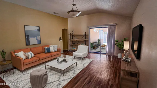 a living room with furniture a flat screen tv and a wooden floor