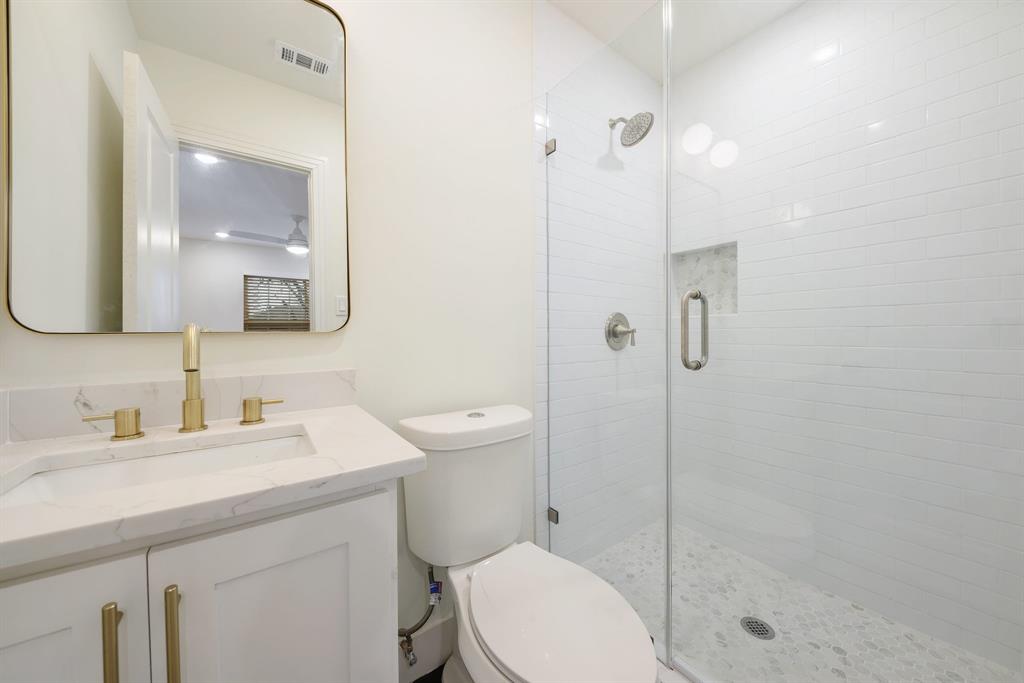 715 Dover Street Dallas, TX 75216 - Photo 5 of 8 Bathroom featuring a glass-enclosed shower with subway tile surround and a tiled floor