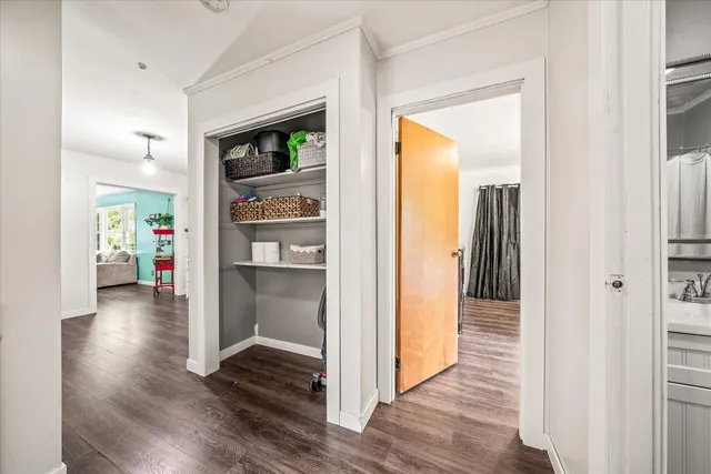 a view of a hallway with wooden floor and a living room