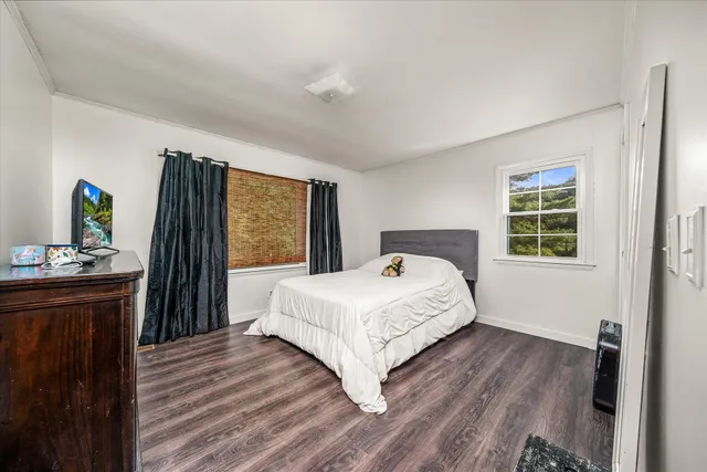 a bedroom with a bed and a dresser next to a window