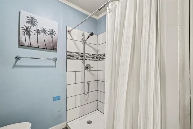 a bathroom with a shower curtain and a window