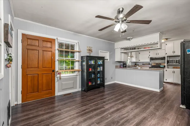 a kitchen with stainless steel appliances wooden floor and a refrigerator