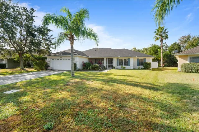a front view of a house with a garden and tree