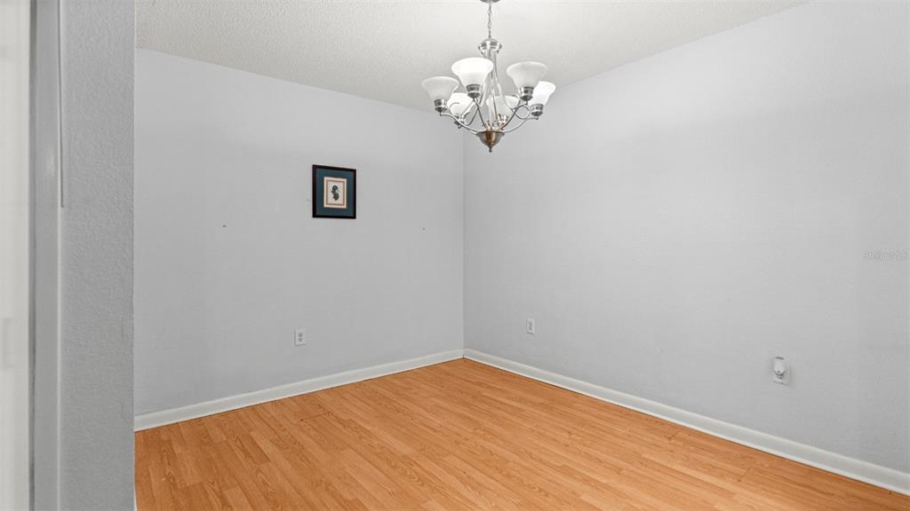 501 Southwest 75th Street, Unit B5 Gainesville, FL 32607 - Photo 7 of 38 a view of a room with a chandelier fan and wooden floor