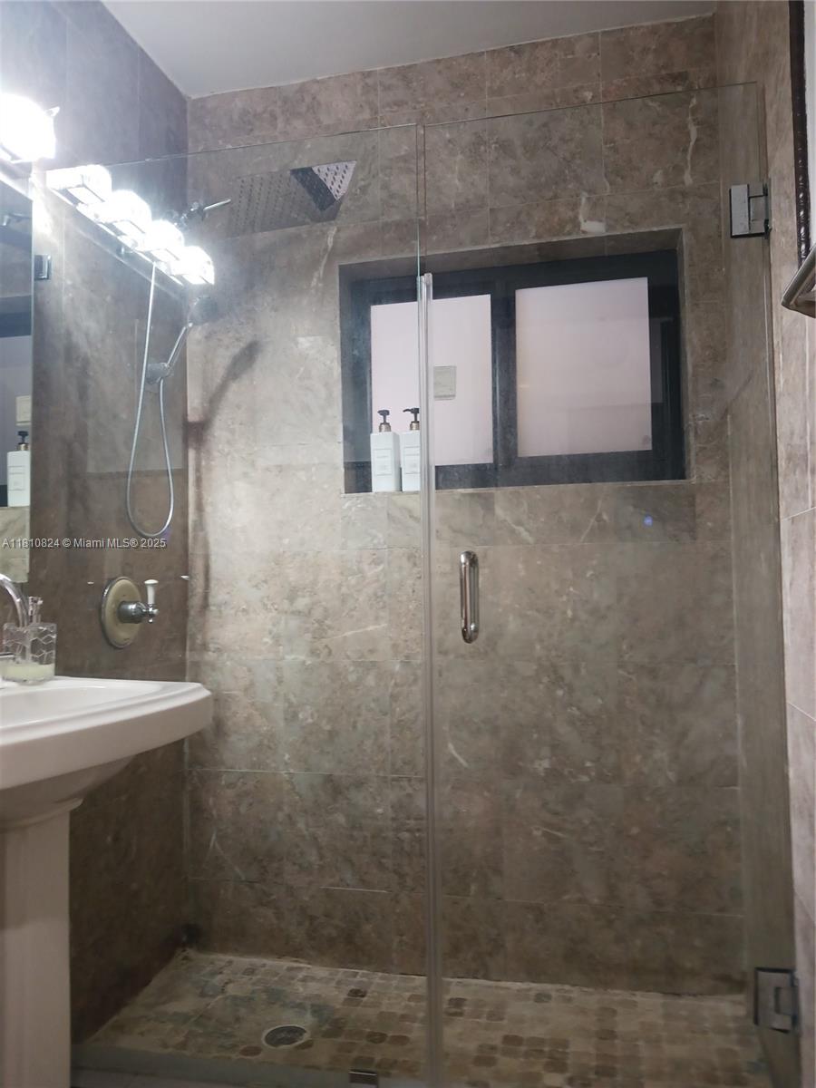 3429 Southwest 23rd Terrace Miami, FL 33145 - Photo 21 of 32 a bathroom with a sink a mirror and shower