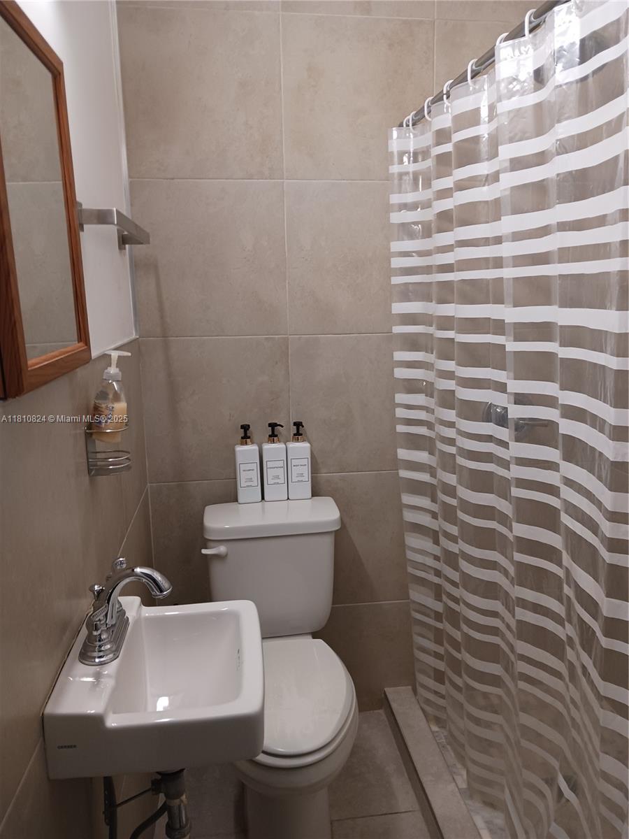 3429 Southwest 23rd Terrace Miami, FL 33145 - Photo 23 of 32 a bathroom with a toilet a sink and mirror