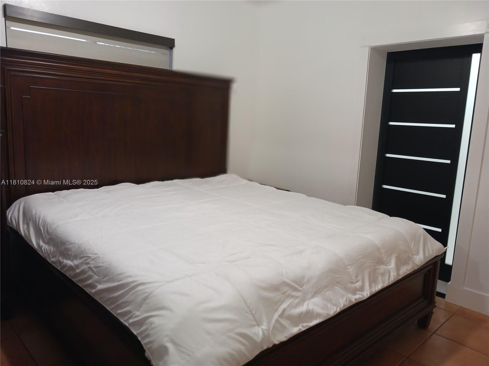 3429 Southwest 23rd Terrace Miami, FL 33145 - Photo 25 of 32 a large bed sitting in a bedroom next to a cabinet
