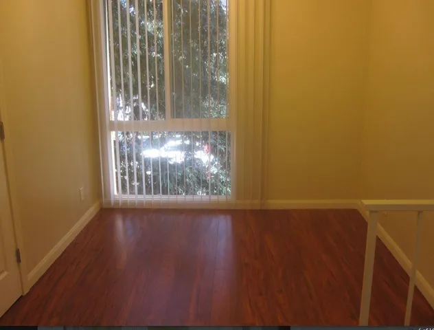 a view of a room with wooden floor and a window