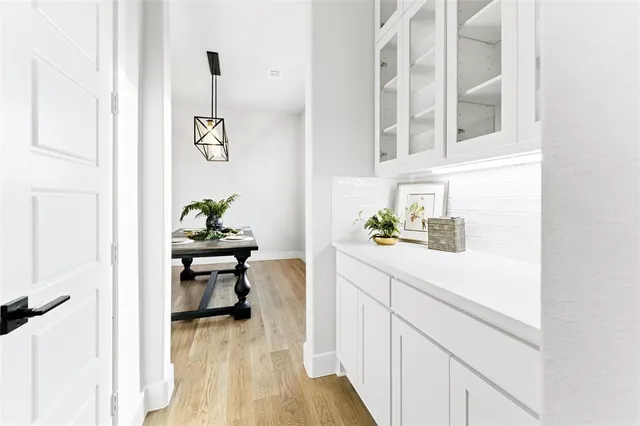 a hallway with a white table and a potted plant