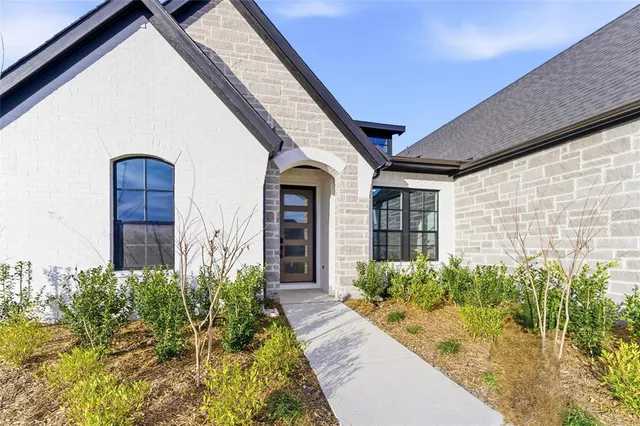 a view of a house with potted plants next to a road