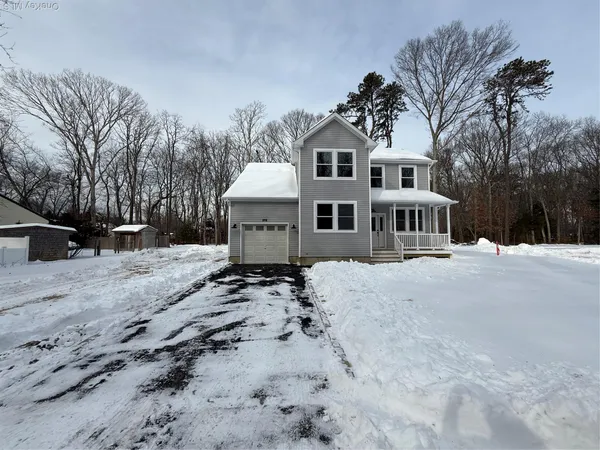 a view of a house with a yard covered in snow