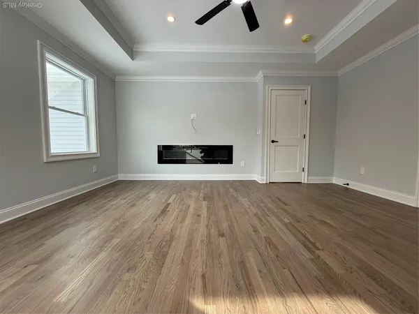 a view of an empty room with wooden floor
