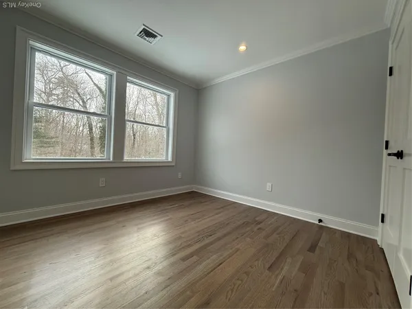 a view of empty room with wooden floor