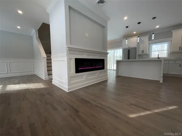 a view of a living room and kitchen with furniture of a fireplace