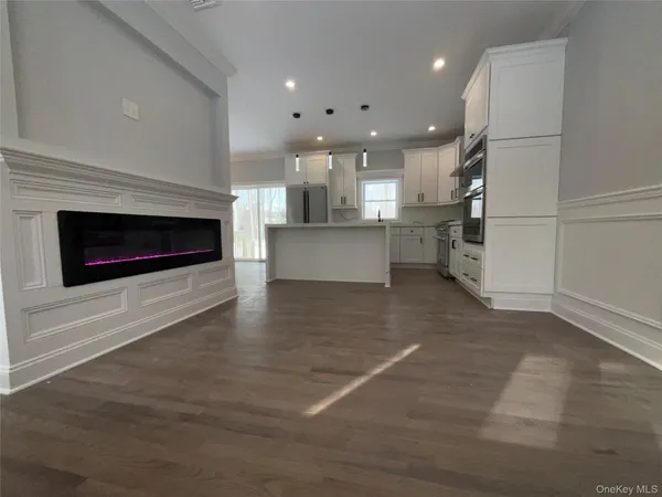 an empty room with wooden floor a fireplace and windows