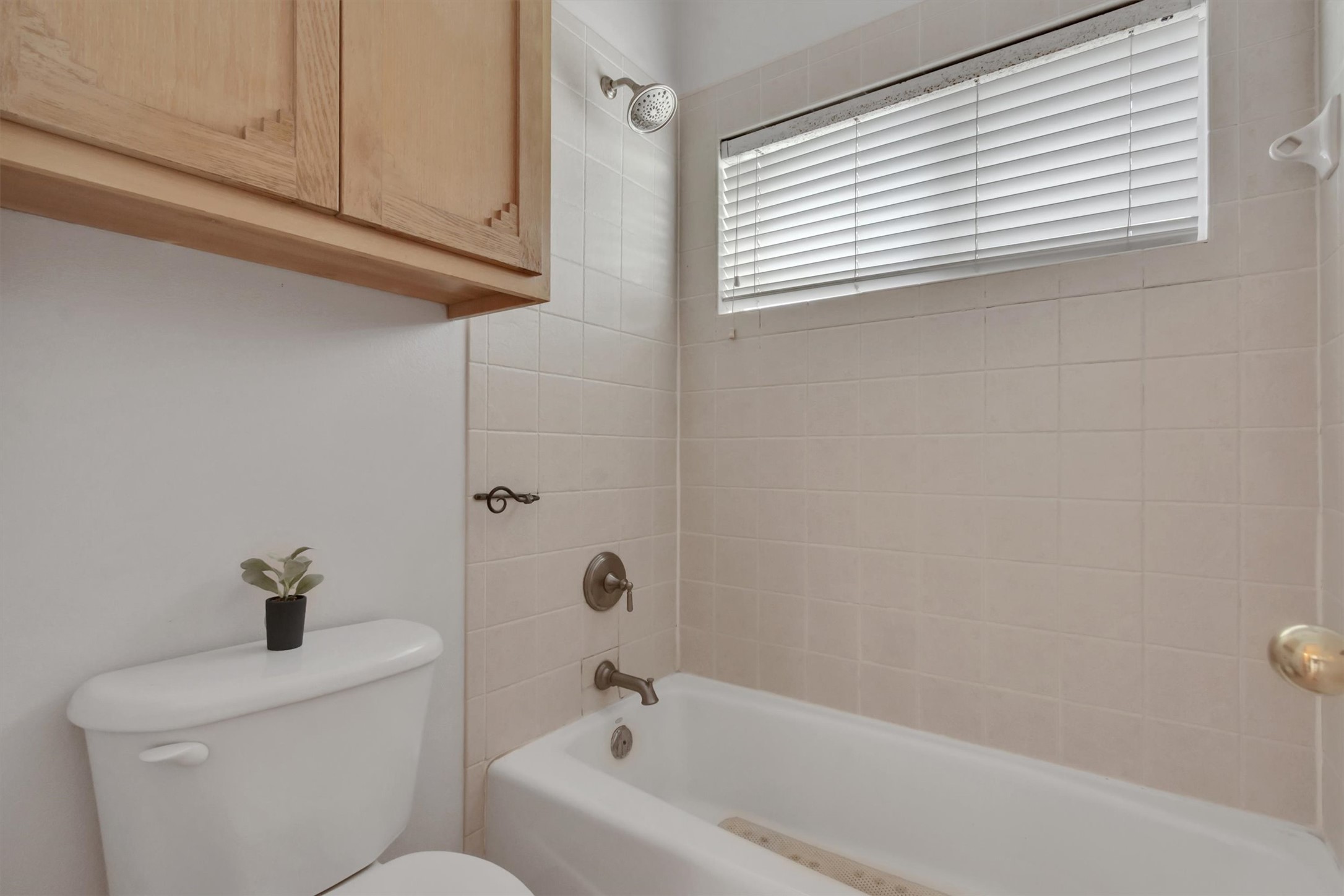 1120 Meadow Ridge Drive Austin, TX 78737 - Photo 23 of 40 A well-maintained bathroom with a tub and shower combination, featuring practical upper cabinetry.