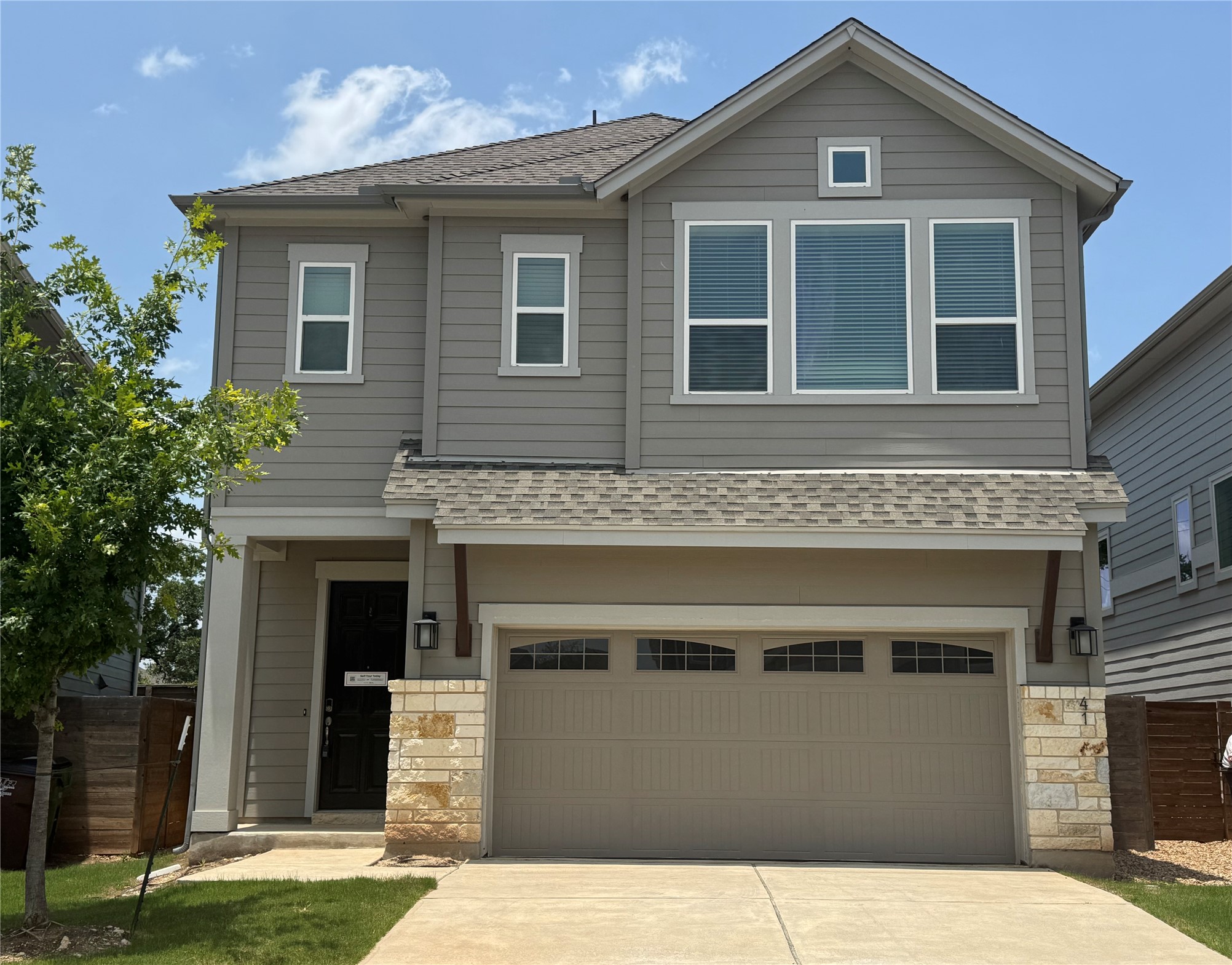 A striking gray two-story residence offers modern design and a welcoming curb appeal.