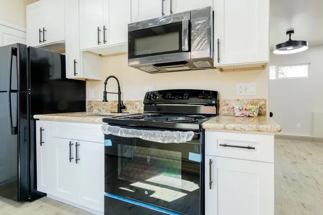 a kitchen with stainless steel appliances granite countertop a stove microwave and refrigerator