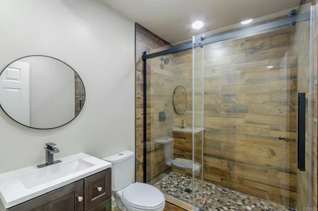 a bathroom with a sink a toilet and shower