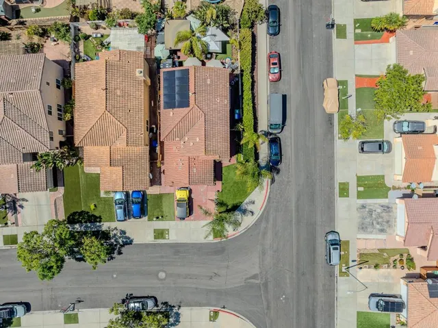 an aerial view of residential houses with outdoor space and parking