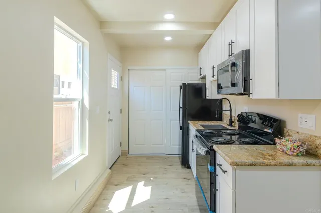 a kitchen with stainless steel appliances granite countertop a stove a sink and a refrigerator