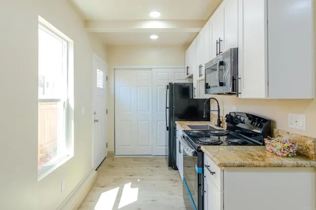 a kitchen with stainless steel appliances granite countertop a refrigerator and a sink