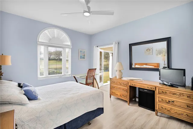 a bedroom with a bed and a flat tv screen on dresser