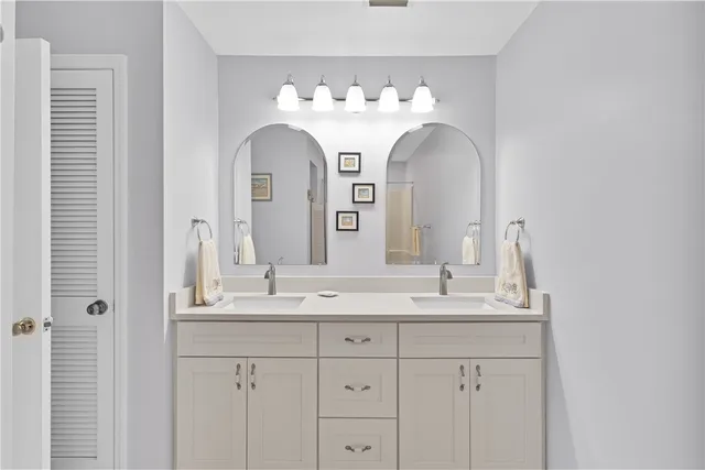 a bathroom with double vanity sinks and a mirror