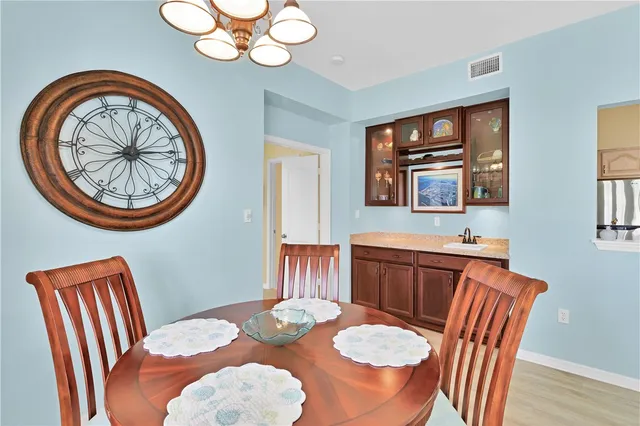 a view of a dining room with furniture a chandelier and wooden floor