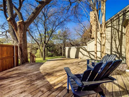 a view of a backyard with table and chairs and wooden fence