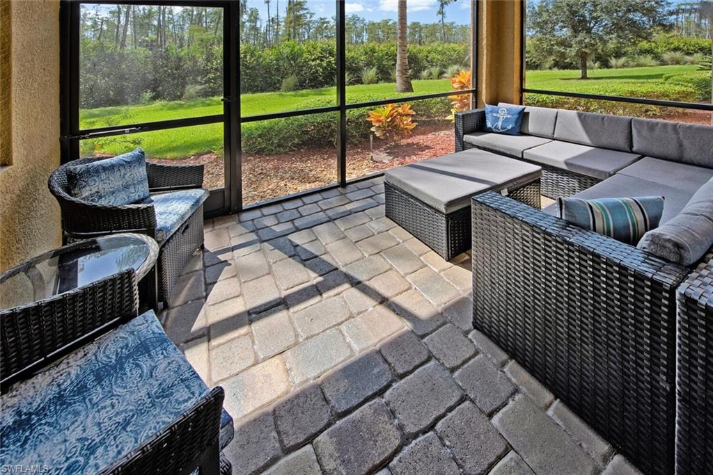 9715 Acqua Court, Unit 116 Naples, FL 34113 - Photo 13 of 33 a view of a patio with a table chairs and a floor to ceiling window