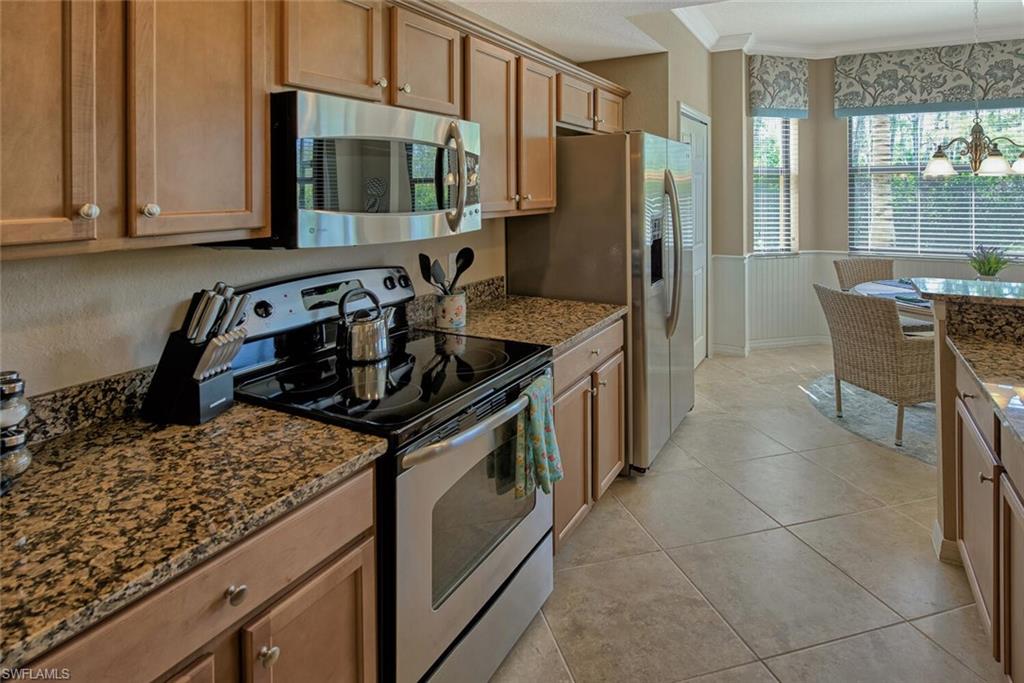 9715 Acqua Court, Unit 116 Naples, FL 34113 - Photo 4 of 33 a kitchen with a stove a sink and a refrigerator