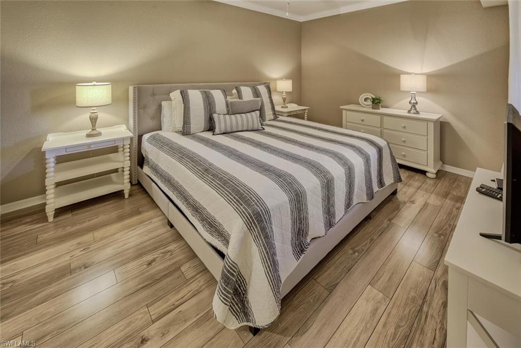 9715 Acqua Court, Unit 116 Naples, FL 34113 - Photo 7 of 33 a bedroom with a bed and a night stand