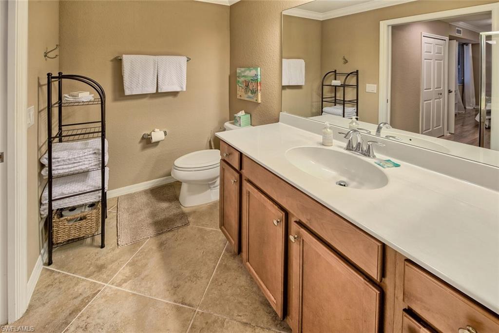9715 Acqua Court, Unit 116 Naples, FL 34113 - Photo 8 of 33 a spacious bathroom with a sink a toilet and a mirror