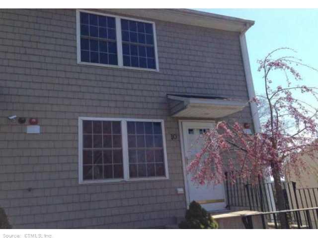 108 Mohican Avenue, Unit 10 Waterbury, CT 06708 - Photo 1 of 1 a view of backyard with brick wall and potted plants