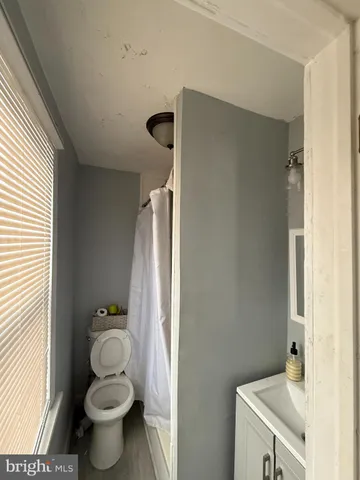 a bathroom with a granite countertop toilet a sink and a mirror