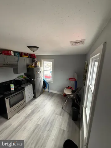 a kitchen with stainless steel appliances kitchen island hardwood floor sink stove and window