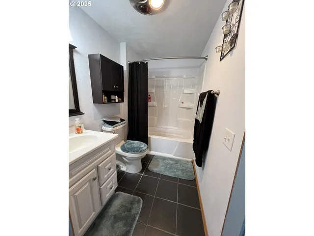 a bathroom with a sink a toilet a mirror and shower