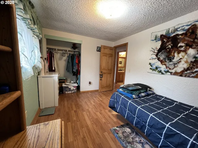 a bedroom with a bed and a wooden floor