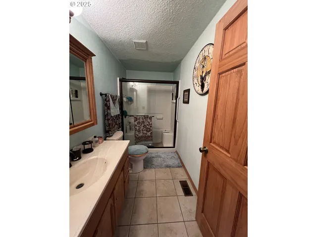a bathroom with a granite countertop shower and a mirror