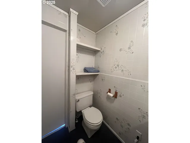 a bathroom with a granite countertop toilet and a sink