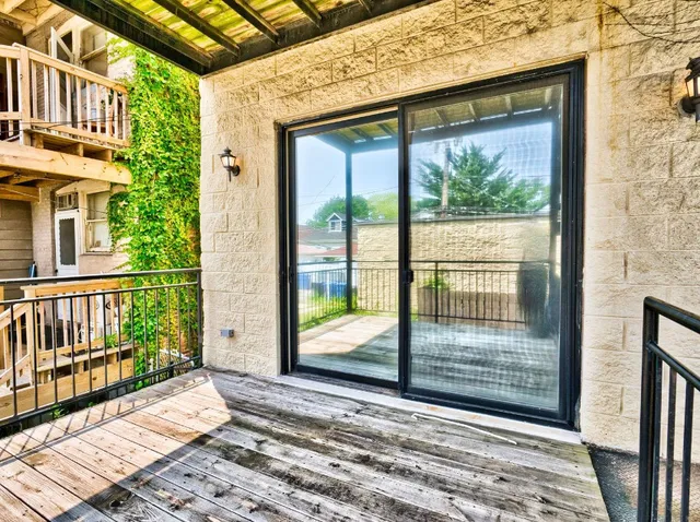 a view of a porch with a floor to ceiling window next to a yard