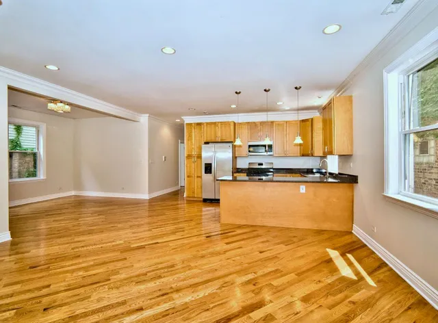 a view of kitchen and kitchen with a sink wooden floor and windows