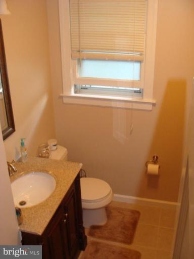 524 Shipley Road Linthicum Heights, MD 21090 - Photo 5 of 7 a bathroom with a granite countertop sink toilet and a mirror