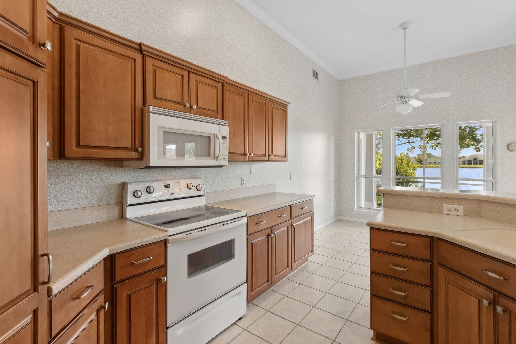 908 Birdie Way St. Augustine, FL 32080 - Photo 18 of 68 a kitchen with stainless steel appliances granite countertop a stove a sink and a microwave