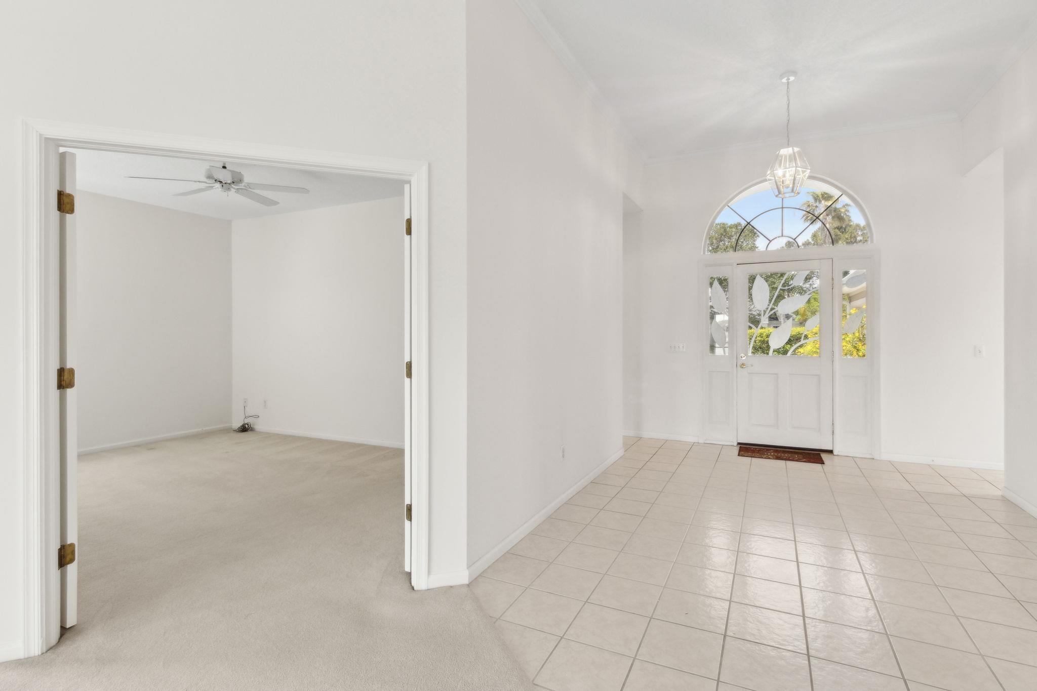 908 Birdie Way St. Augustine, FL 32080 - Photo 53 of 68 an empty room with windows and chandelier