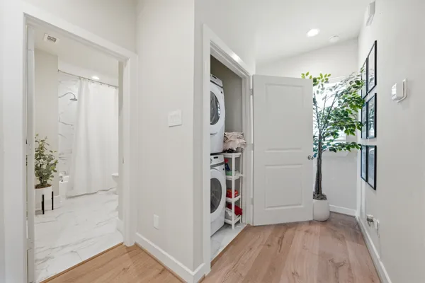 a view of a hallway with wooden floor and a potted plant