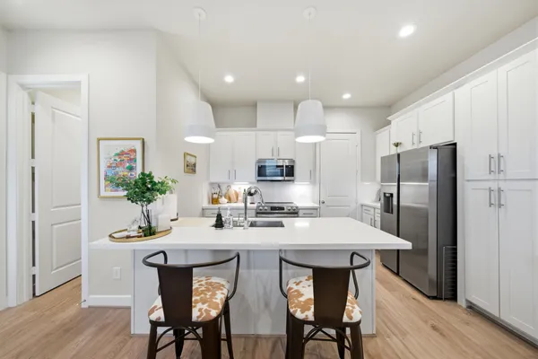 a kitchen with refrigerator cabinets dining table and chairs