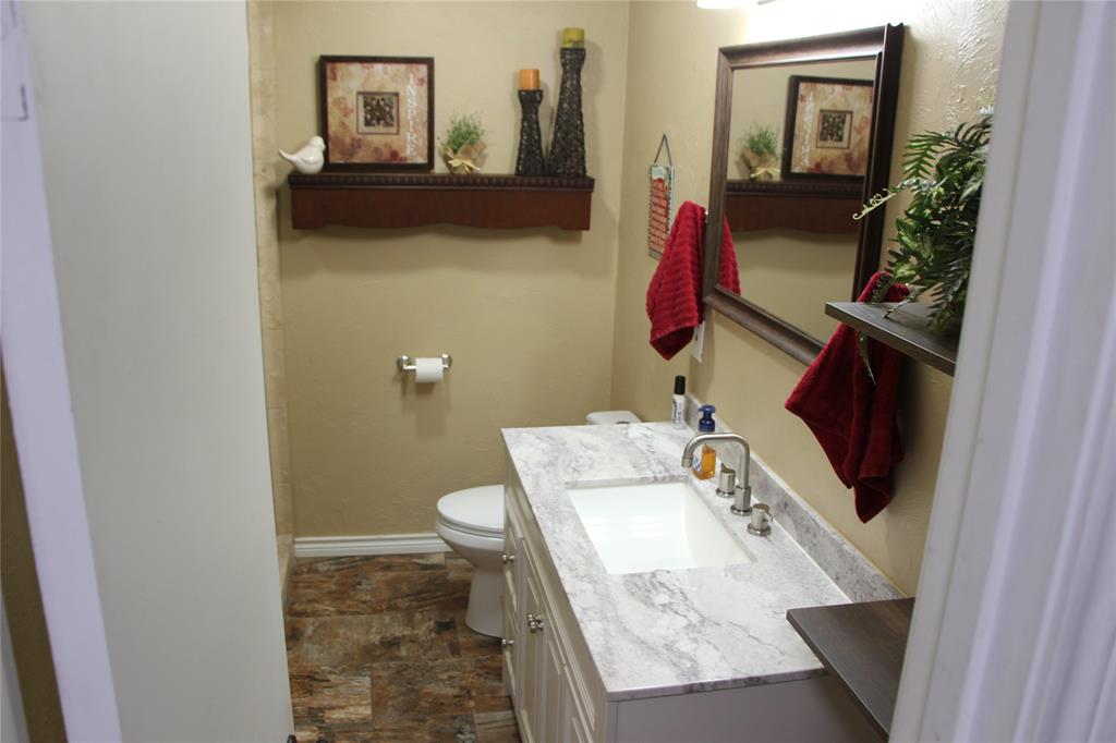 800 Griffin Road Albany, TX 76430 - Photo 8 of 15 a bathroom with a sink toilet and mirror
